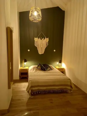 a bedroom with a large bed and a chandelier at Les chambres d'hôtes du Relais d'Aguilar in Tuchan