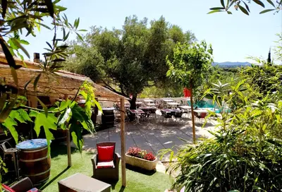 a garden with a patio with tables and chairs at Les chambres d'hôtes du Relais d'Aguilar in Tuchan