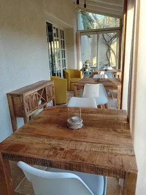 a dining room with a wooden table and white chairs at MaCoCo Maison Coeur Corbieres in Fontjoncouse
