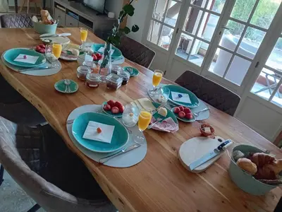 a wooden table with plates of food on it at MaCoCo Maison Coeur Corbieres in Fontjoncouse