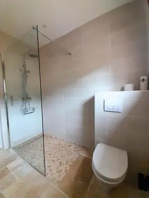 a bathroom with a toilet and a glass shower at MaCoCo Maison Coeur Corbieres in Fontjoncouse