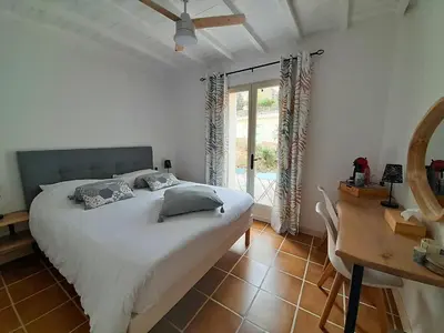 a bedroom with a bed and a desk and a window at MaCoCo Maison Coeur Corbieres in Fontjoncouse