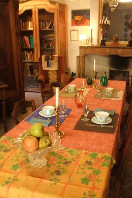 a table with fruits and candles on top of it at La Vigne Bleue in Olonzac