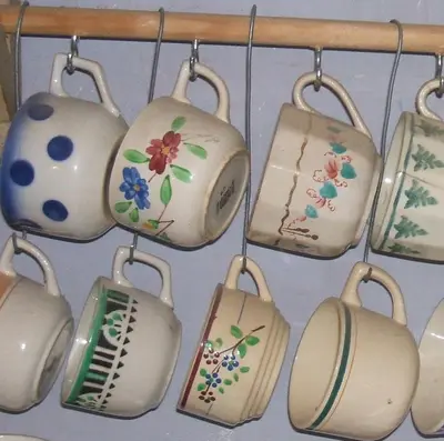 a bunch of pots and pans hanging from a wall at La Vigne Bleue in Olonzac
