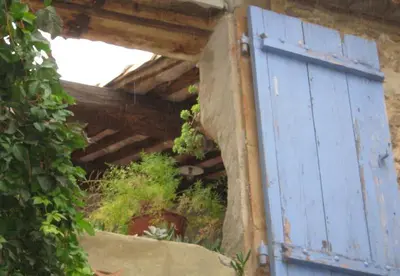 a blue door on the side of a building at La Vigne Bleue in Olonzac