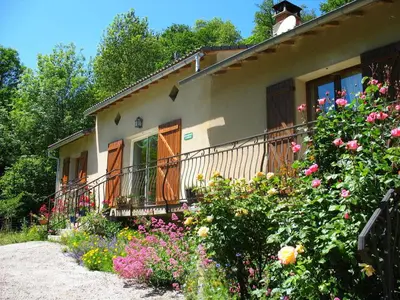 a house with a bunch of flowers in front of it at Le Moulin du Barthas in Montredon-Labessonnié