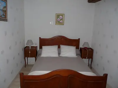 a bedroom with a large bed with two night stands at Gîte La Maison du Meunier in Montredon-Labessonnié