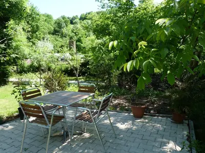 a table and chairs sitting on a patio at Gîte La Maison du Meunier in Montredon-Labessonnié
