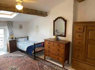 a bedroom with a bed and a dresser and a mirror at Cheerful, traditional 3 bedroom home in Quillan in Quillan