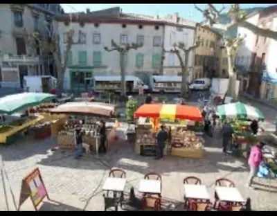 an outdoor market with tables and umbrellas in a city at Cheerful, traditional 3 bedroom home in Quillan in Quillan