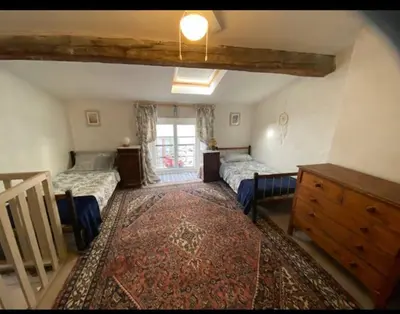 a bedroom with two beds and a dresser and a window at Cheerful, traditional 3 bedroom home in Quillan in Quillan