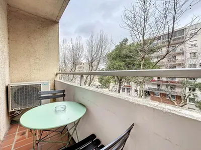 a balcony with a green table and chairs on it at Studio Cosy - Balcon - Wifi - Free parking in Narbonne