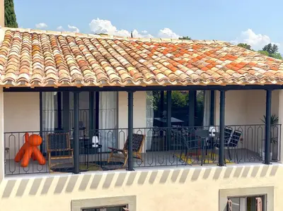 a balcony with chairs and an orange figure on it at Gîte au pied de la Cité Médiévale - Le 127 in Carcassonne