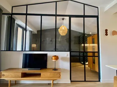 a living room with a tv and a desk at Gîte au pied de la Cité Médiévale - Le 127 in Carcassonne