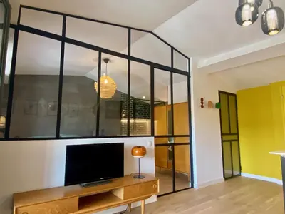 a living room with a large glass wall at Gîte au pied de la Cité Médiévale - Le 127 in Carcassonne