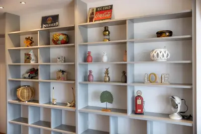 a shelf filled with lots of vases and other items at Sous les remparts la maison Pimprenelle in Carcassonne