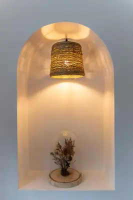 a light and a vase with a plant in a room at Sous les remparts la maison Pimprenelle in Carcassonne