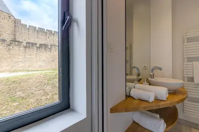 a bathroom with a sink and a window at Sous les remparts la maison Pimprenelle in Carcassonne