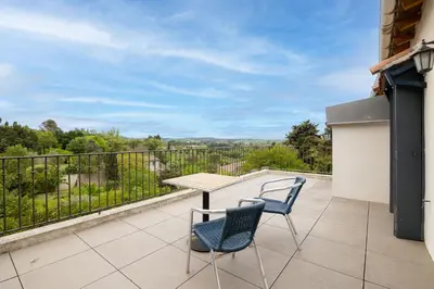 a patio with a table and chairs on a balcony at Sous les remparts la maison Pimprenelle in Carcassonne