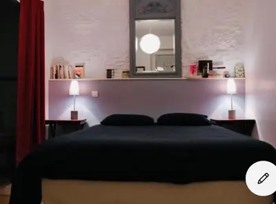 a bedroom with a bed with a mirror and two lamps at Maison centre historique Le Préau saint Jacques in Castres