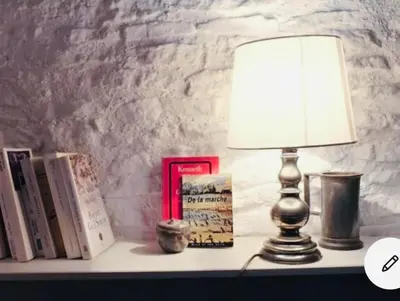 a lamp sitting on a table with books at Maison centre historique Le Préau saint Jacques in Castres