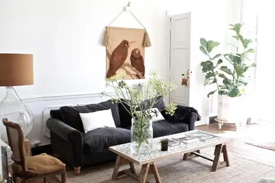 a living room with a black couch and a table at Camellas-Lloret in Montréal