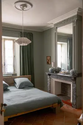 a bedroom with a bed with a fireplace and a mirror at Camellas-Lloret in Montréal
