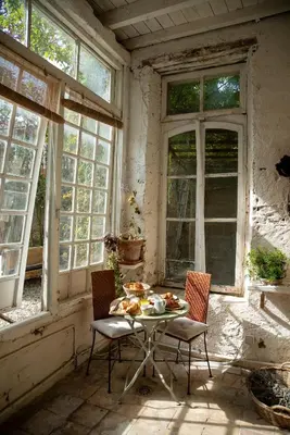 a table and chairs in a room with windows at Camellas-Lloret in Montréal