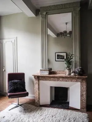 a living room with a fireplace and a mirror at Camellas-Lloret in Montréal
