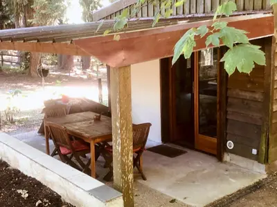 a cabin with a wooden table and chairs and a porch at La Cabane in Mazamet