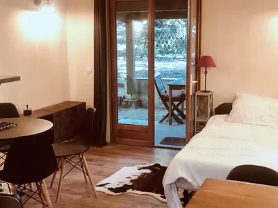 a bedroom with a bed and a desk and a table at La Cabane in Mazamet