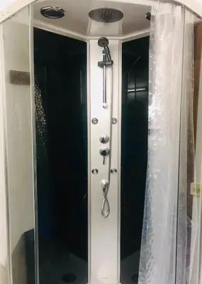 a shower in a bathroom with a shower curtain at La Cabane in Mazamet