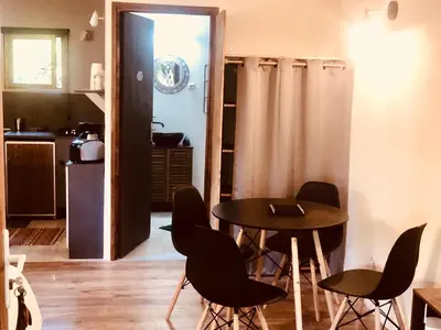 a room with a table and chairs and a kitchen at La Cabane in Mazamet