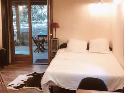 a bedroom with a bed and a door to a patio at La Cabane in Mazamet