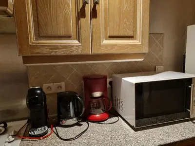 a kitchen counter with a microwave and various appliances at Le Gîte Dame Nature in La Tourette-Cabardès