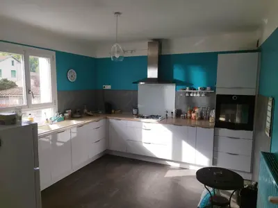 a kitchen with white cabinets and blue walls at La Maison de Raph in Villeneuve dʼOlmes