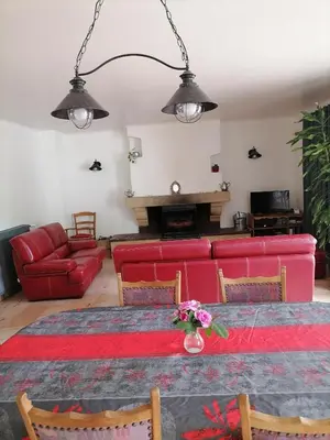 a living room with a red couch and a table at La Maison de Raph in Villeneuve dʼOlmes