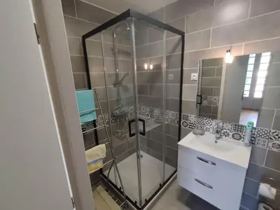 a bathroom with a glass shower and a sink at La Maison de Raph in Villeneuve dʼOlmes