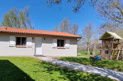a small white house with a ladder in the yard at Gîte à la Ferme de la Bouriette in Revel