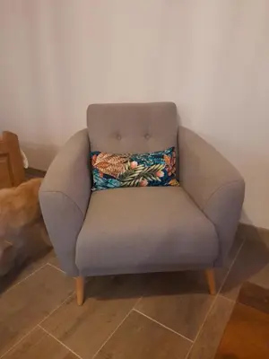 a gray chair with a pillow on top of it at L'atelier des rêves in Capestang