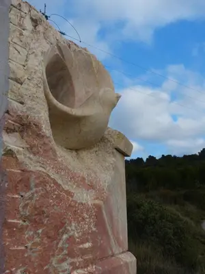 a statue of a bird sitting in a pot on a wall at L'Incarnat in Caunes-Minervois
