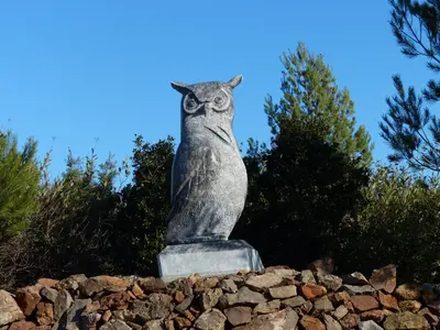 a statue of an owl sitting on top of a stone wall at L'Incarnat in Caunes-Minervois