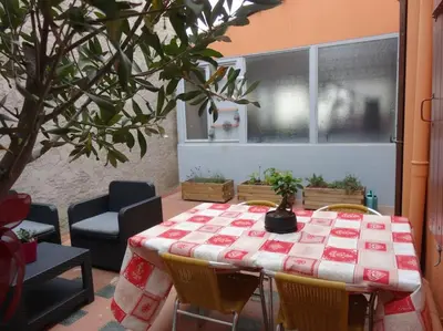 a table with a red and white table cloth on it at Appartement spacieux avec grand patio, 1er étage in Sigean