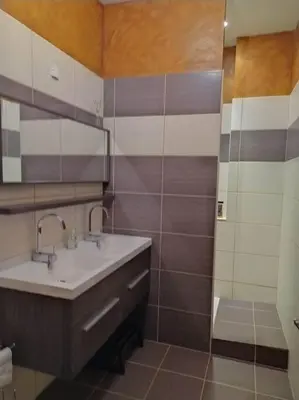 a bathroom with a sink and a mirror at Appartement spacieux avec grand patio, 1er étage in Sigean