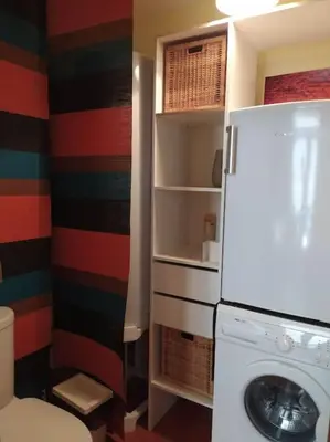 a kitchen with a refrigerator and a washing machine at Appartement spacieux avec grand patio, 1er étage in Sigean
