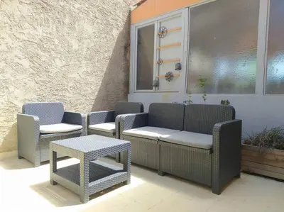 a group of chairs and tables on a patio at Appartement spacieux avec grand patio, 1er étage in Sigean