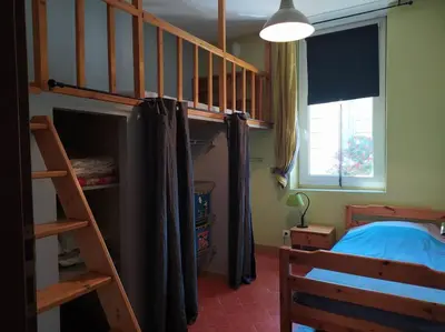 a bedroom with a bunk bed and a staircase at Appartement spacieux avec grand patio, 1er étage in Sigean