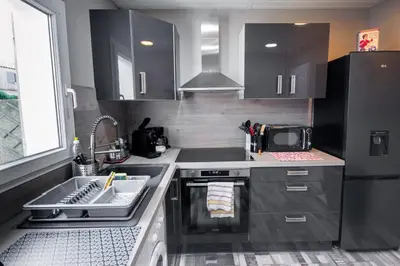 a small kitchen with a sink and a refrigerator at La Maisonnette YourHostHelper in Gruissan