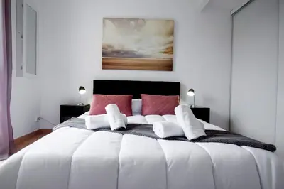 a bedroom with a large white bed with red pillows at La Maisonnette YourHostHelper in Gruissan