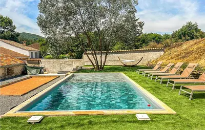 a swimming pool with chairs and a hammock in a yard at Stunning Home In Pardailhan in Pardailhan